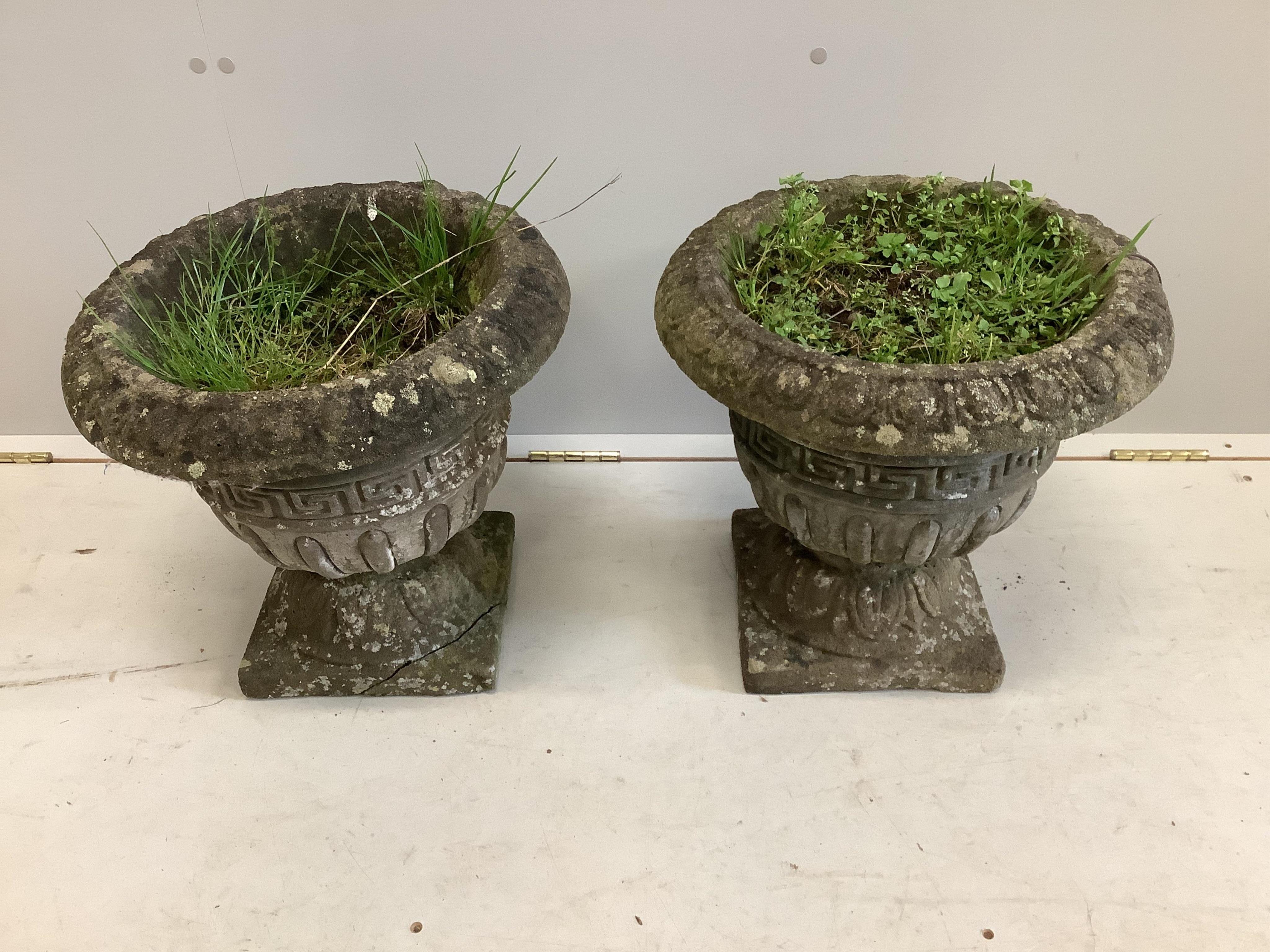 A pair of reconstituted stone circular campana garden urns, diameter 40cm, height 38cm. Condition - poor to fair